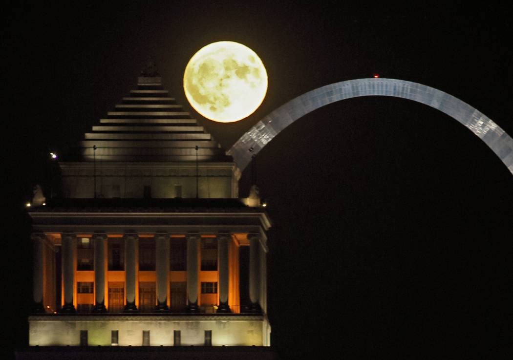 The harvest moon rises over the St. Louis skyline and the Arch on Friday, Sept. 13, 2019. (Davi ...