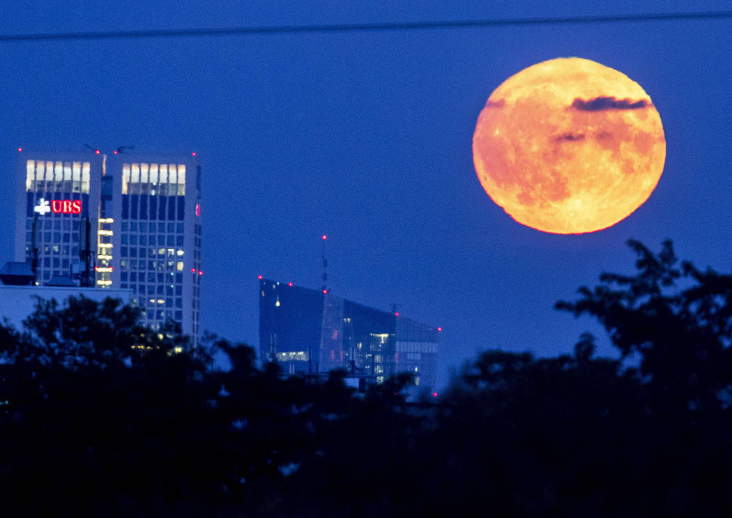 The full moon rises over the European Central Bank, center, in Frankfurt, Germany, Friday, Sept ...