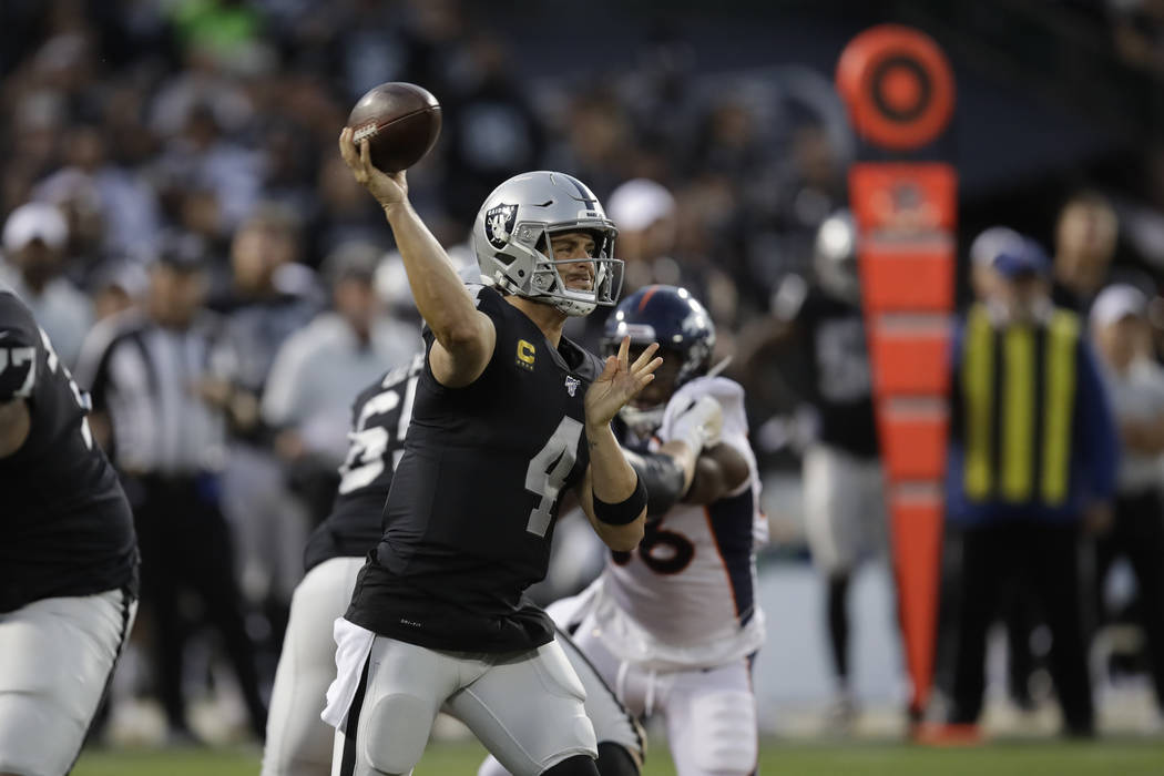 Oakland Raiders quarterback Derek Carr throws during the first half of an NFL football game aga ...
