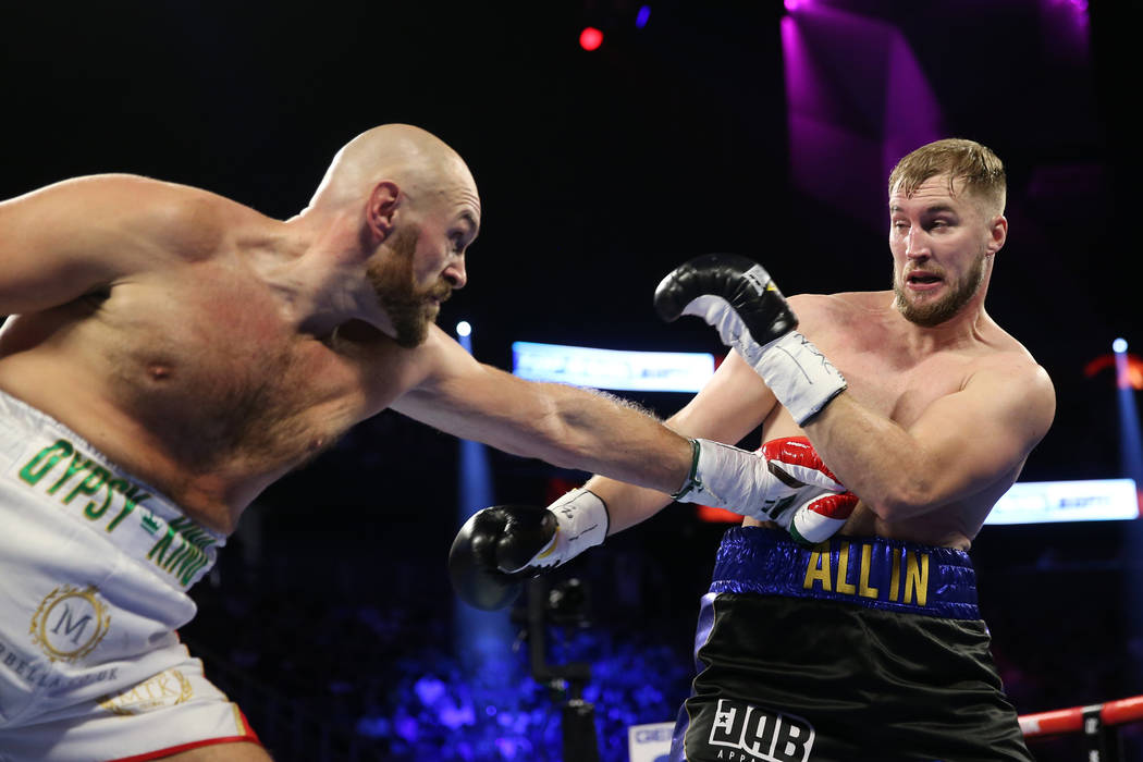 Tyson Fury, left, throws a punch against Otto Wallin in the first round of the heavyweight bout ...