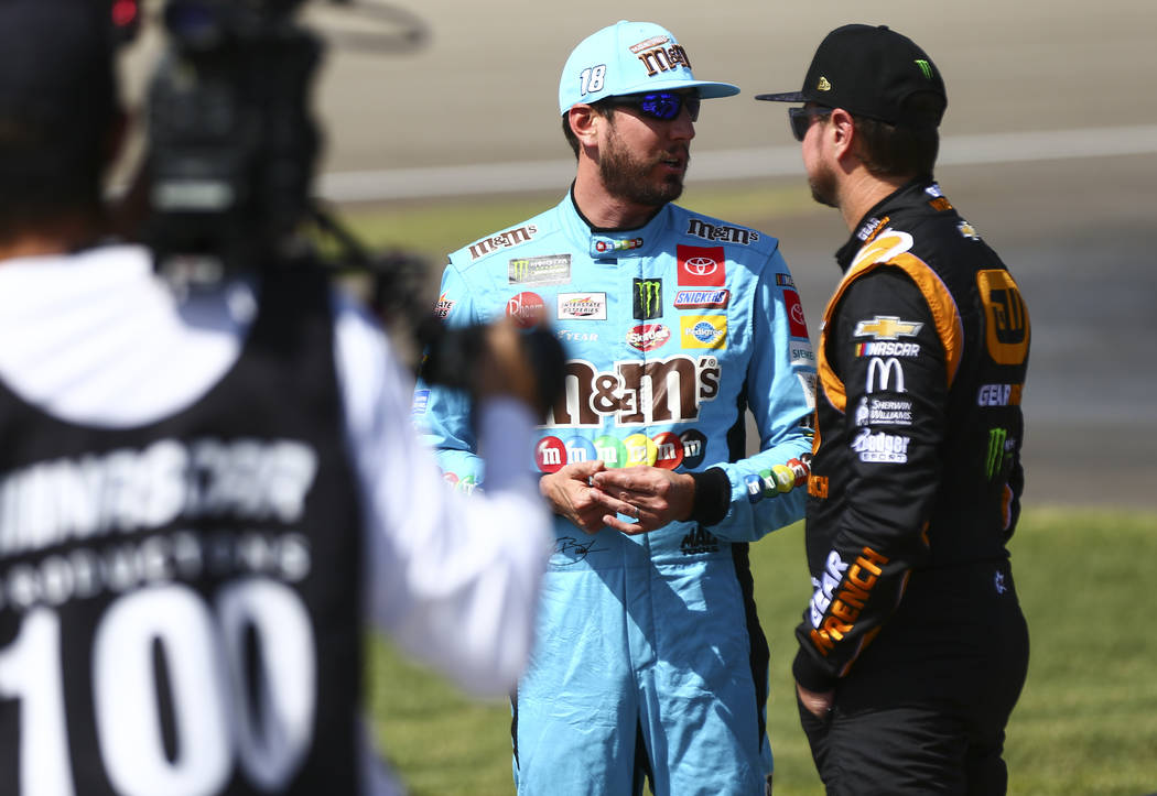 Kyle Busch, left, talks with Kurt Busch before qualifying for a NASCAR Cup Series auto race at ...