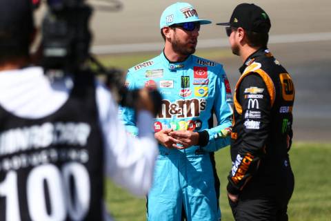 Kyle Busch, left, talks with Kurt Busch before qualifying for a NASCAR Cup Series auto race at ...