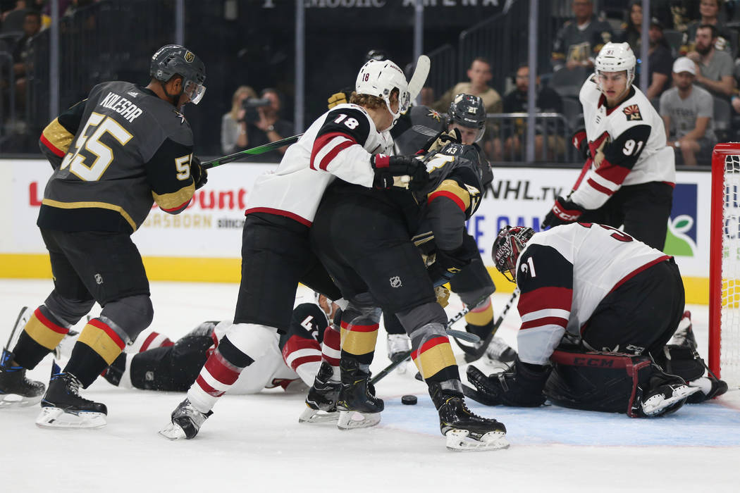 Players battles for the puck during the first period of an NHL preseason hockey game between th ...