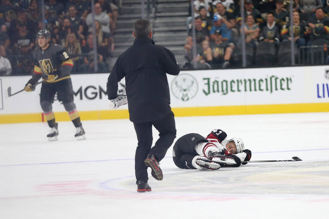 Arizona Coyotes defenseman Aaron Ness (42) falls after taking a hit from Vegas Golden Knights r ...