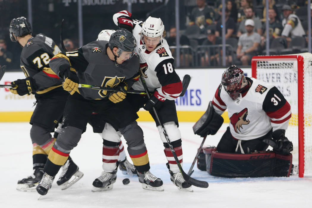 Vegas Golden Knights left wing Curtis McKenzie (11) fights for the puck against Arizona Coyotes ...