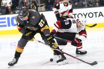Golden Knights defenseman Shea Theodore (27) tries to get the puck from Arizona Coyotes center ...