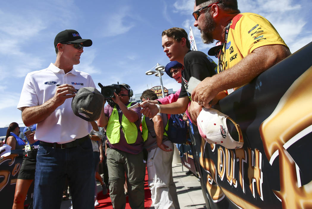 Kevin Harvick gives autographs to fans before a NASCAR Cup Series auto race at Las Vegas Motor ...