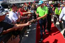 Kyle Busch gives autographs to fans before a NASCAR Cup Series auto race at Las Vegas Motor Spe ...