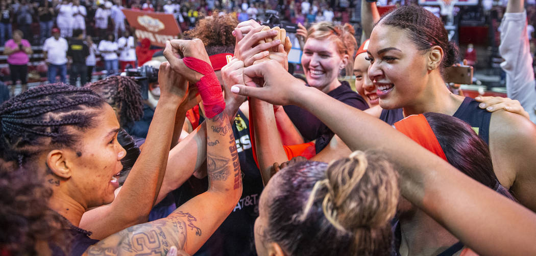 Las Vegas Aces forward Tamera Young (1, left) looks center Liz Cambage (8, right) as teammates ...