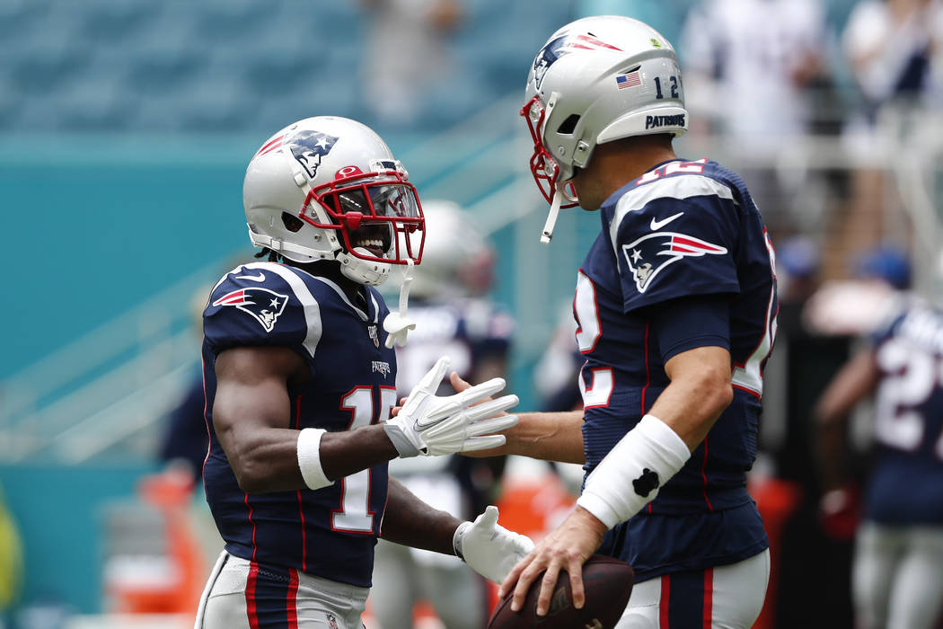 New England Patriots quarterback Tom Brady (12) greets wide receiver Antonio Brown (17) before ...