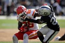 Kansas City Chiefs running back Damien Williams tries to break away from Oakland Raiders free s ...