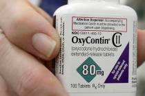 A pharmacist in San Francisco holds a bottle of OxyContin. (AP Photo/Jeff Chiu)