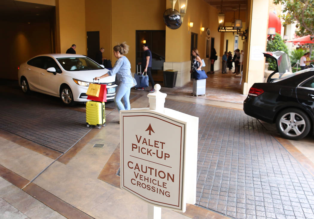Hotel guests at Wynn Las Vegas prepare to load their luggage into their car at valet parking pi ...
