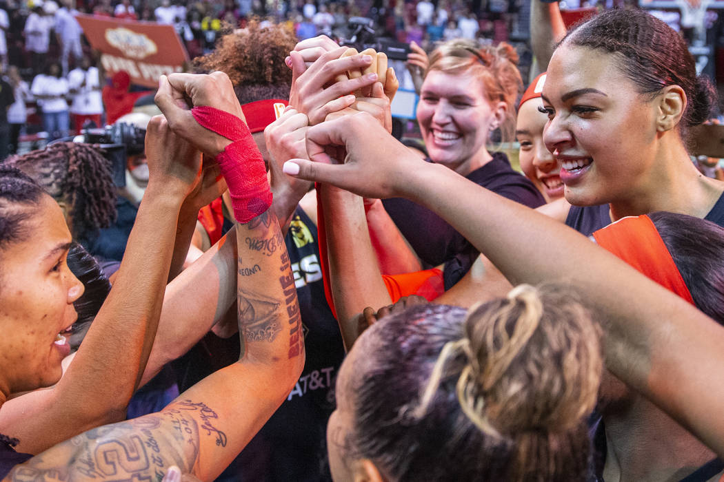 Las Vegas Aces forward Tamera Young (1, left) looks center Liz Cambage (8, right) as teammates ...