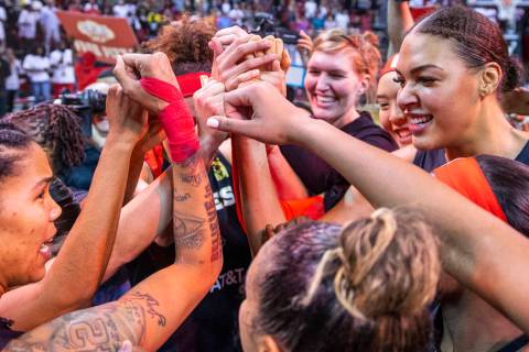 Las Vegas Aces forward Tamera Young (1, left) looks center Liz Cambage (8, right) as teammates ...
