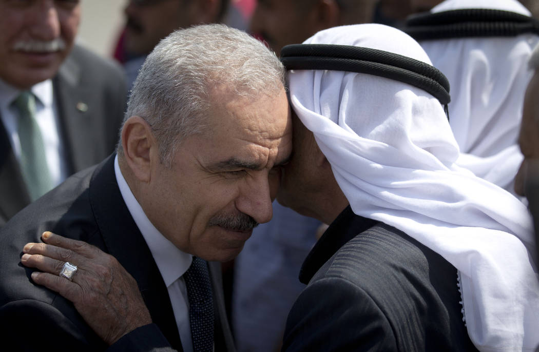 Palestinian Prime Minister Mohammed Shtayyeh, left, arrives for a cabinet meeting in the Jordan ...