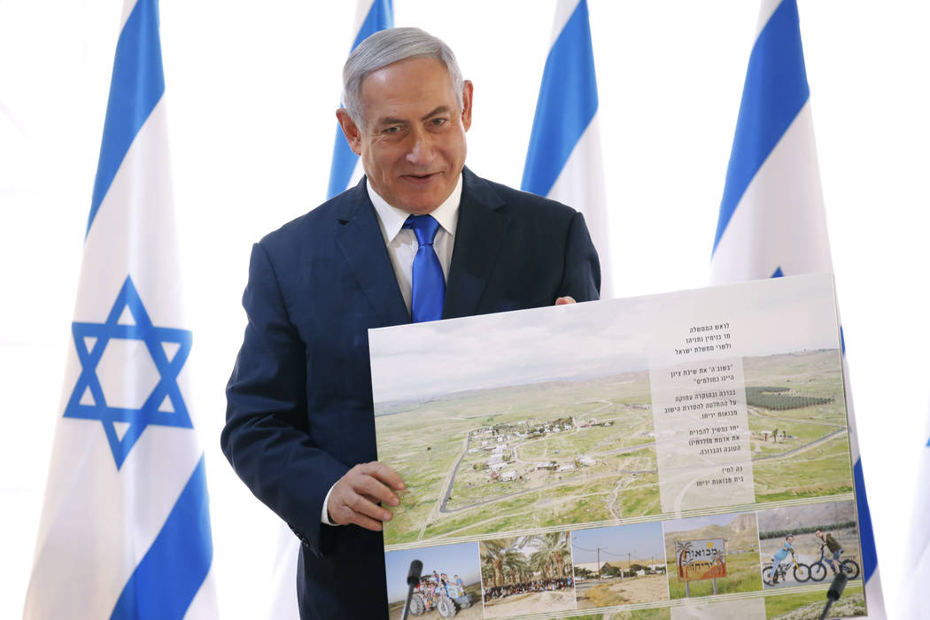 Israeli Prime Minister Benjamin Netanyahu holds up a placard given to him as a gift from Israel ...