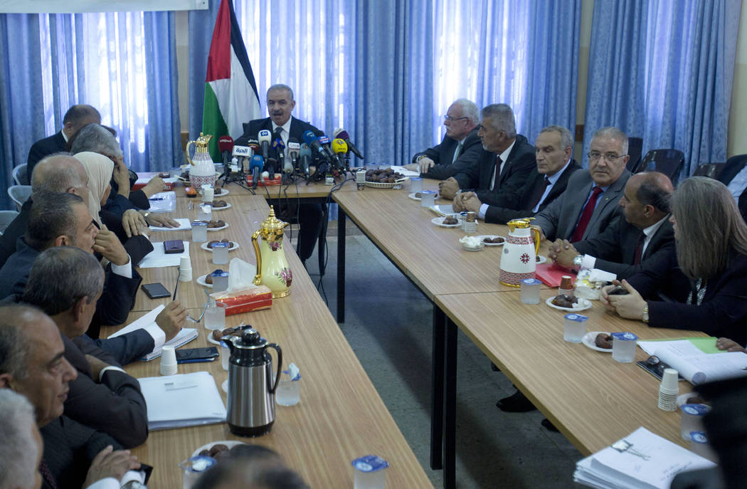 Palestinian Prime Minister Mohammed Shtayyeh, center, chairs a cabinet meeting in the Jordan Va ...