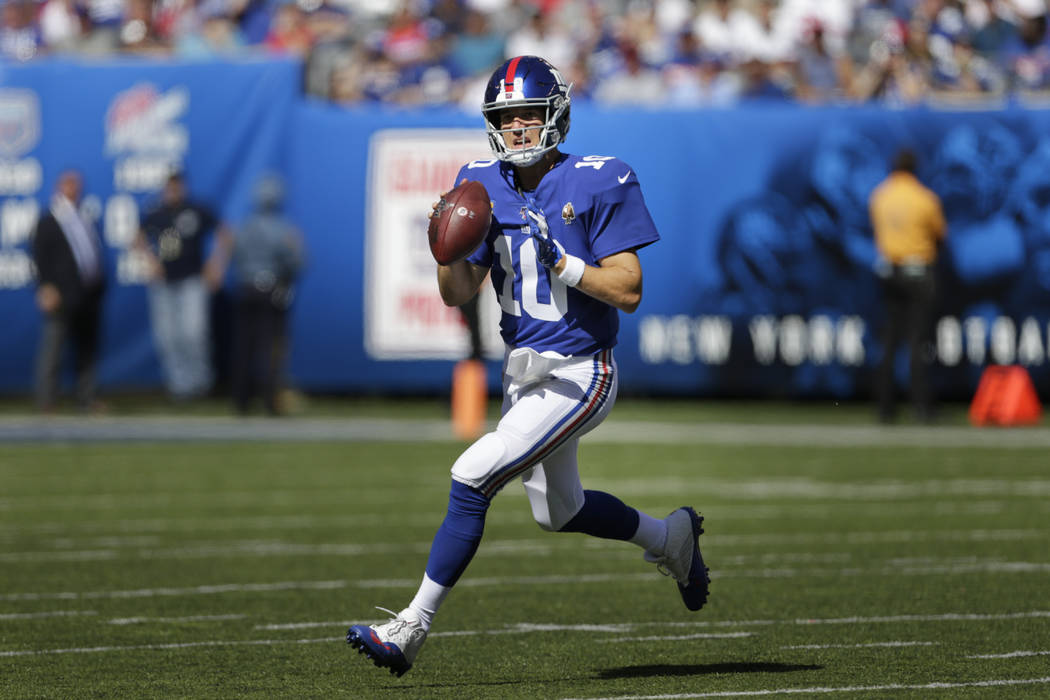 New York Giants quarterback Eli Manning looks to pass while under pressure during the second ha ...