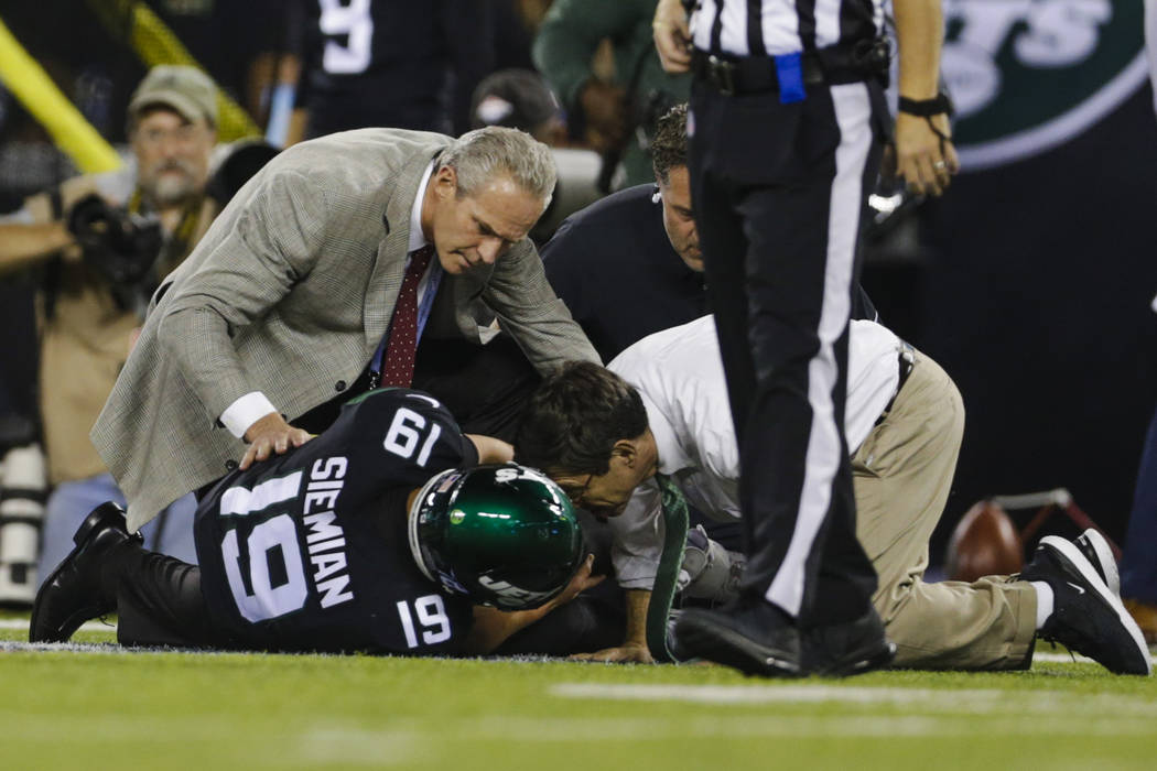 Trainers check on New York Jets quarterback Trevor Siemian (19) after he was injured during the ...