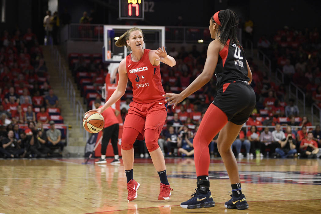 Washington Mystics center Emma Meesseman, left, dribbles the ball in front of Las Vegas Aces ce ...