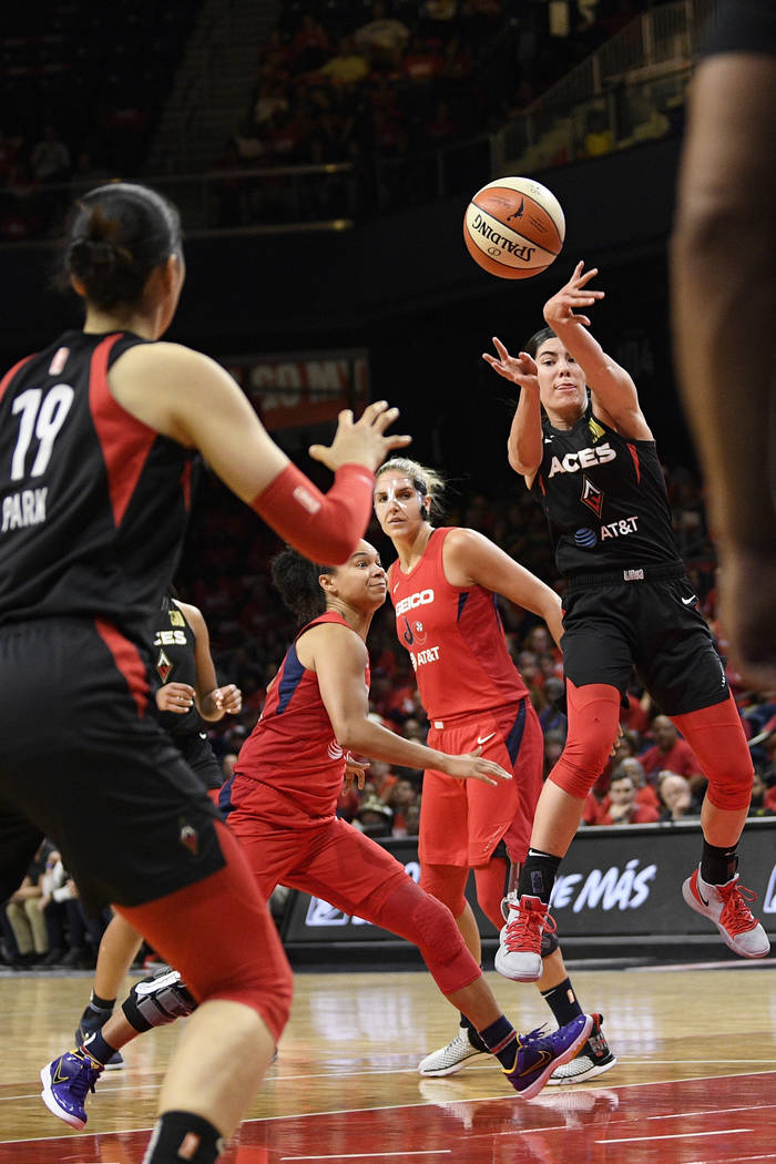 Las Vegas Aces guard Kelsey Plum, right, passes the ball toward center Ji-Su Park (19), past Wa ...