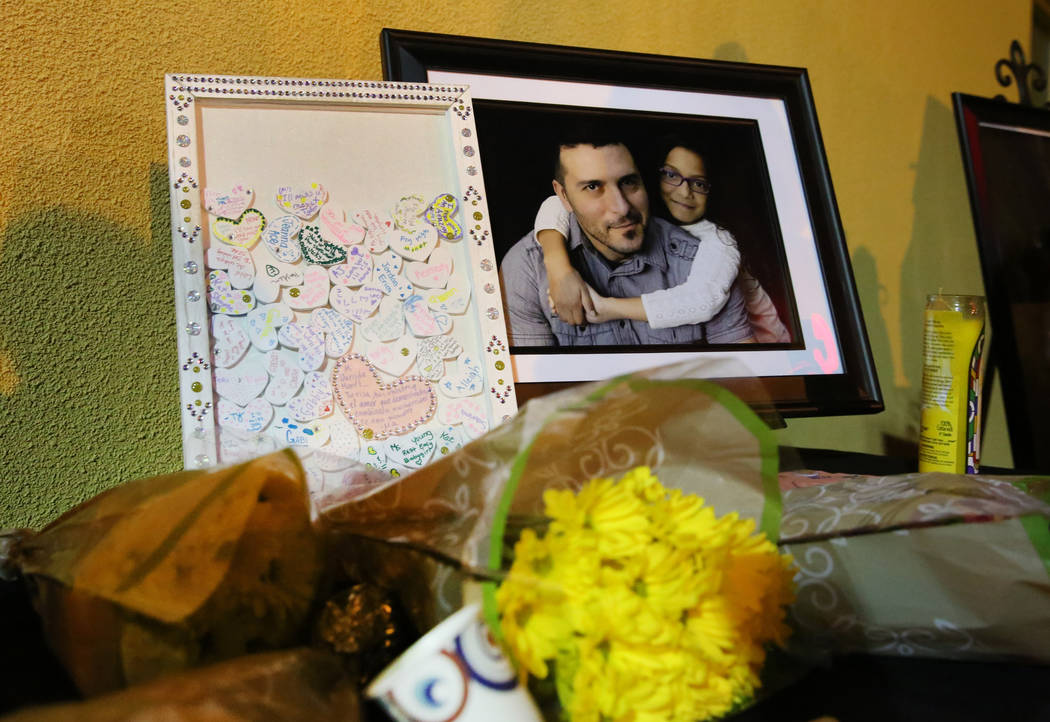 A bouquet of flowers lies next to a photograph of Mark Garcia and his daughter Monet during a c ...