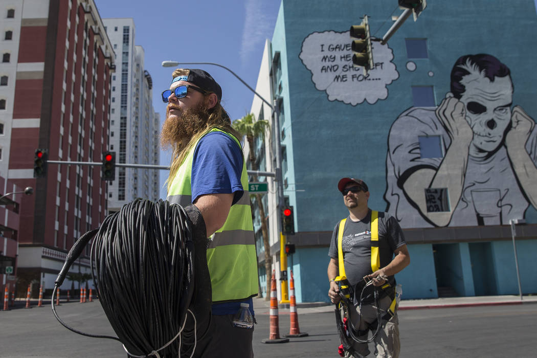 Big Vision entertainment workers Nick Werst, left, and Shane Smith run fiber for camera and vid ...