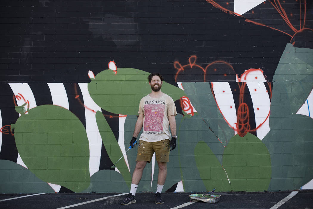 Artist Eric Vozzola stands in front of his mural-in-progress "An Allegory of Natural Beaut ...