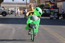 Sasha Romandetti of Las Vegas rides her bike with "Gilbert the Alien" in downtown Las Vegas on ...