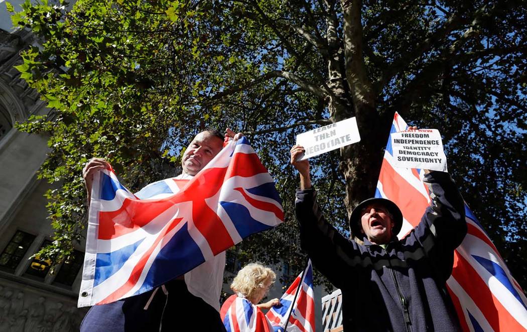 Demonstrators hold placards and flags outside the Supreme Court in London, Wednesday, Sept. 18, ...