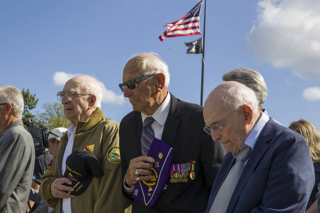 World War II veterans Clarence Smoyer, 96, left, Joseph Caserta and Buck Marsh bow their heads ...
