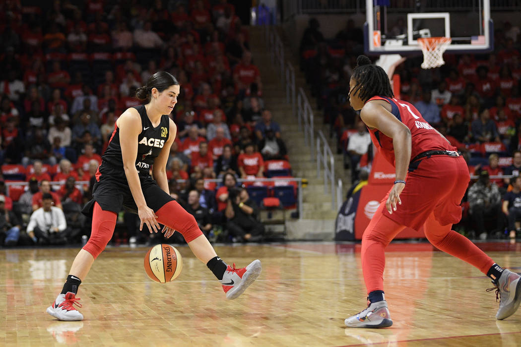 Las Vegas Aces guard Kelsey Plum, left, dribbles the ball against Washington Mystics guard Arie ...