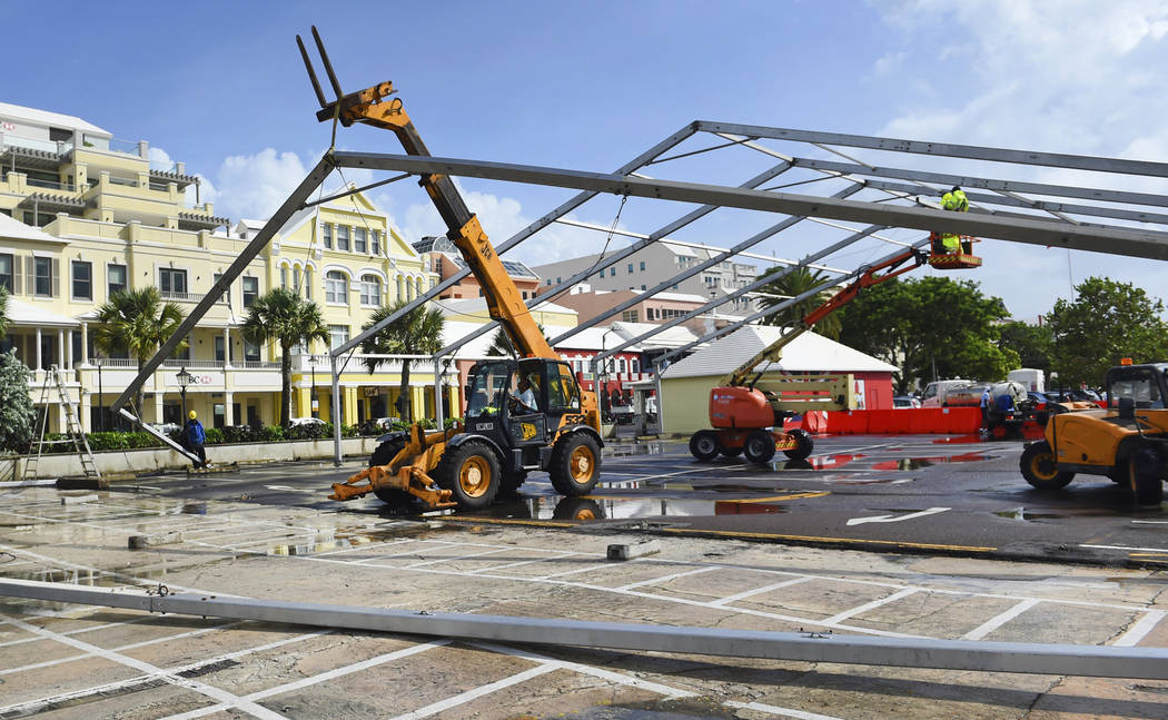 Workers take down a tent frame in preparation for Hurricane Humberto in Hamilton, Bermuda, Wedn ...