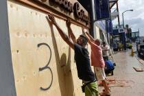 People board up an Urban Cottage store in preparation for Hurricane Humberto in Hamilton, Bermu ...