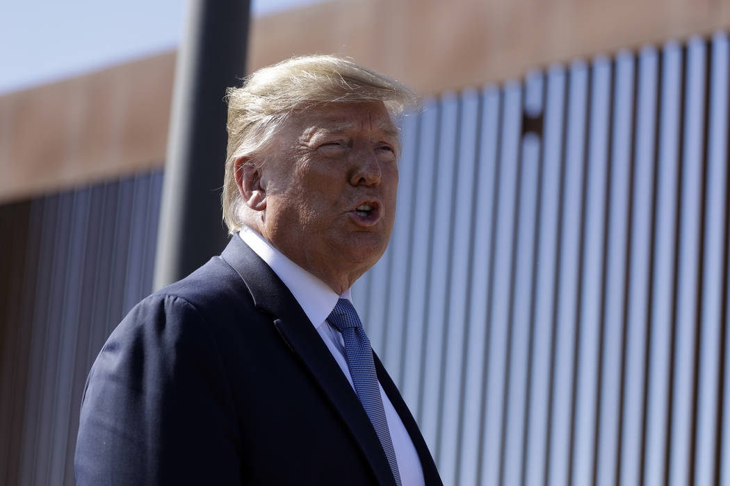 President Donald Trump talks with reporters as he tours a section of the southern border wall, ...