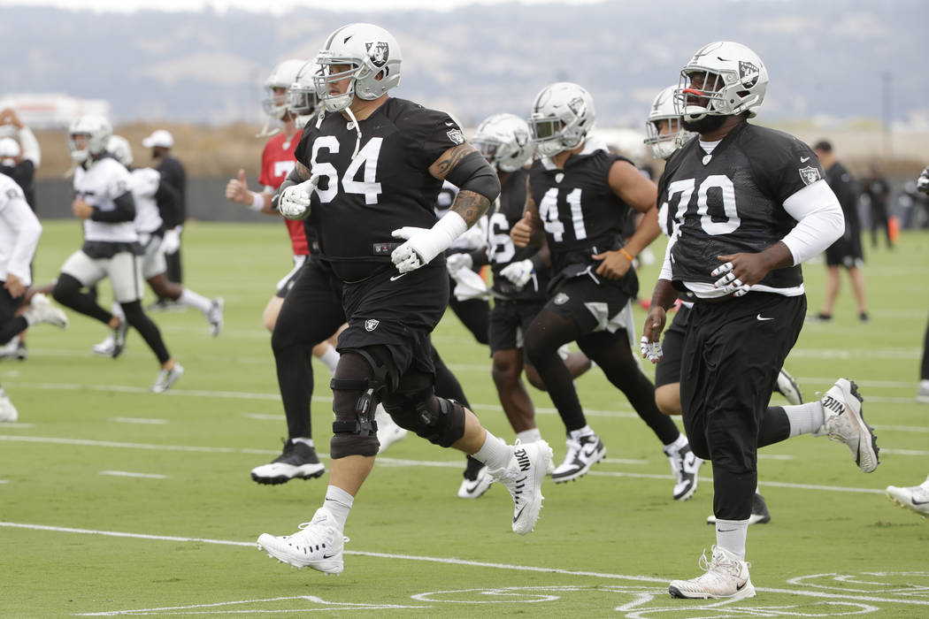 Oakland Raiders' Richie Incognito (64) jogs next to Jonathan Cooper (70) during NFL football pr ...