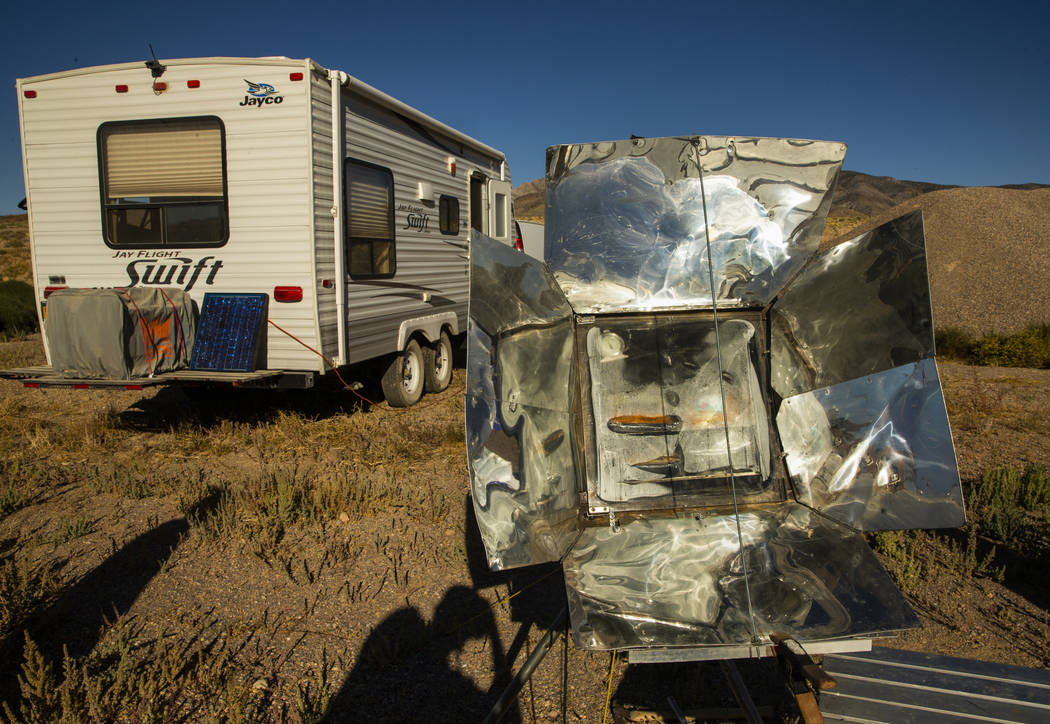 Ken Faulhaber of Las Vegas cooks dinner in a solar over while camped out with friends as the Al ...