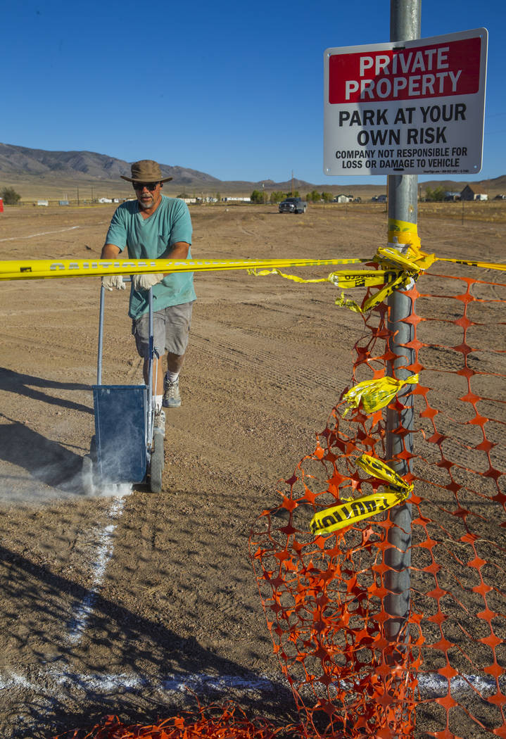 Douglas Benedetti chalks out parking lines across from the Little A'Le'Inn which is the site of ...