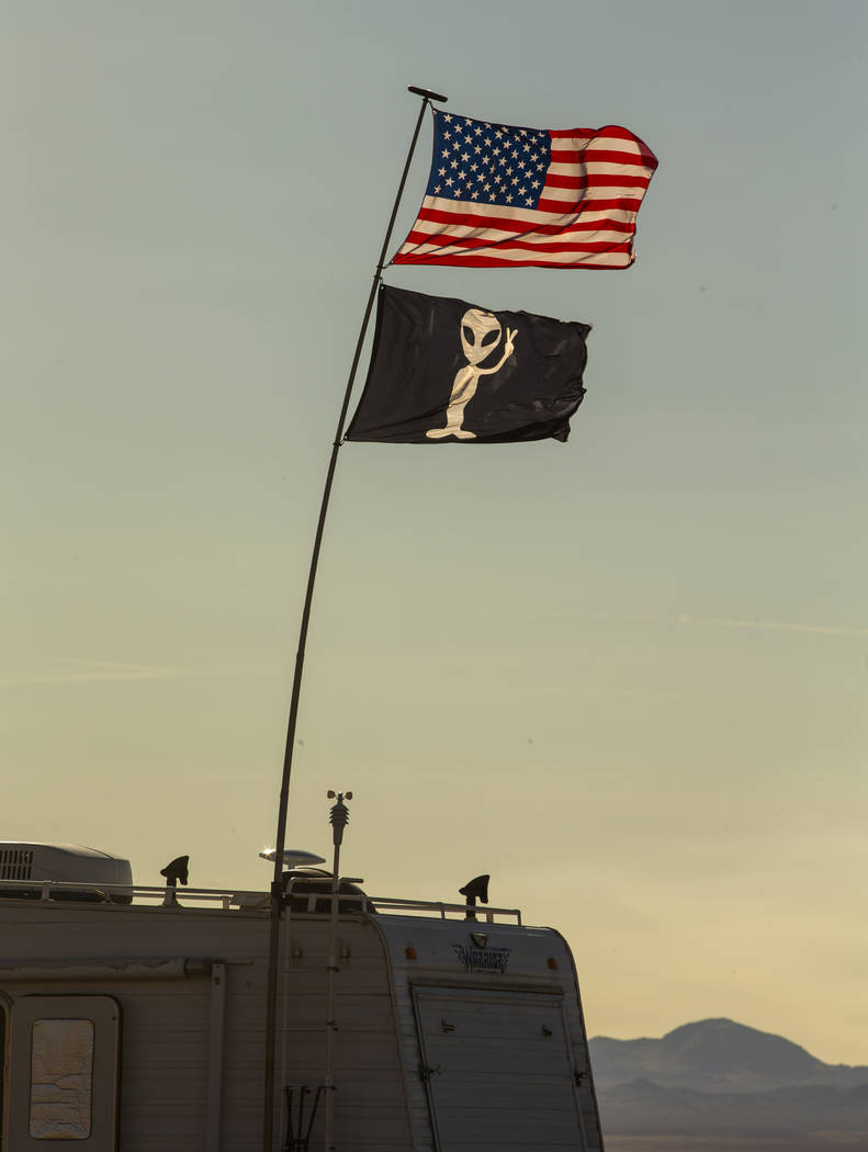 Two flags fly above and RV which is camped out in the desert as the Alienstock and Area 51 Base ...