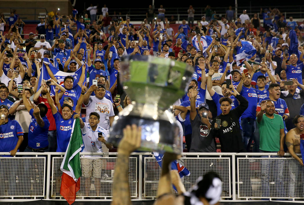 Fans celebrate with Cruz Azul's Edgar Mendez (17) holding the trophy after defeating Tigres 2-1 ...