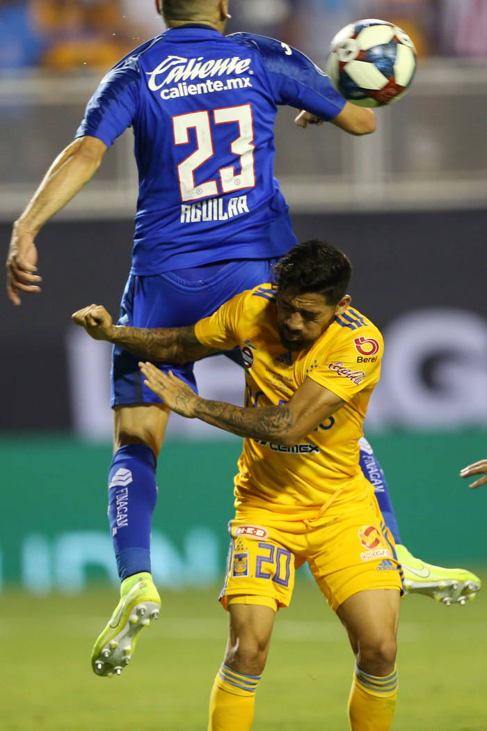 Tigres' Javier Aquino (20) and Cruz Azul's Pablo Aguilar (23) leap for the ball during the seco ...
