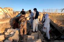 Afghan security members and people work at the site of a suicide attack in Zabul, Afghanistan, ...