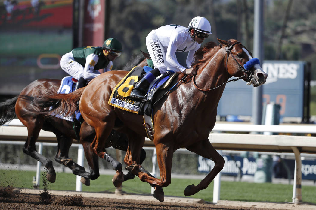 Justify, ridden by Mike Smith, gallops past Bolt d'Oro, left, with jockey Javier Castellano, du ...