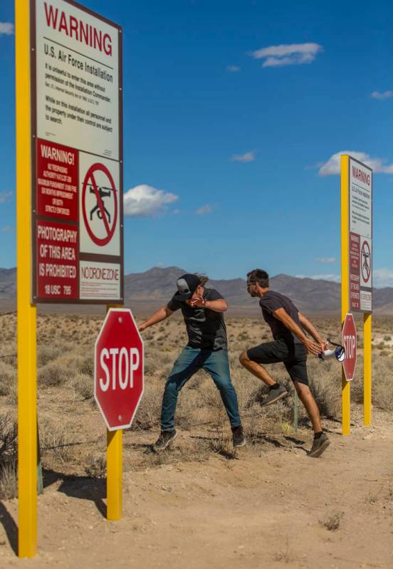 Devin Caldarone, left, and Mike Dye of Los Angeles pretend to cross into Area 51 past the fake ...
