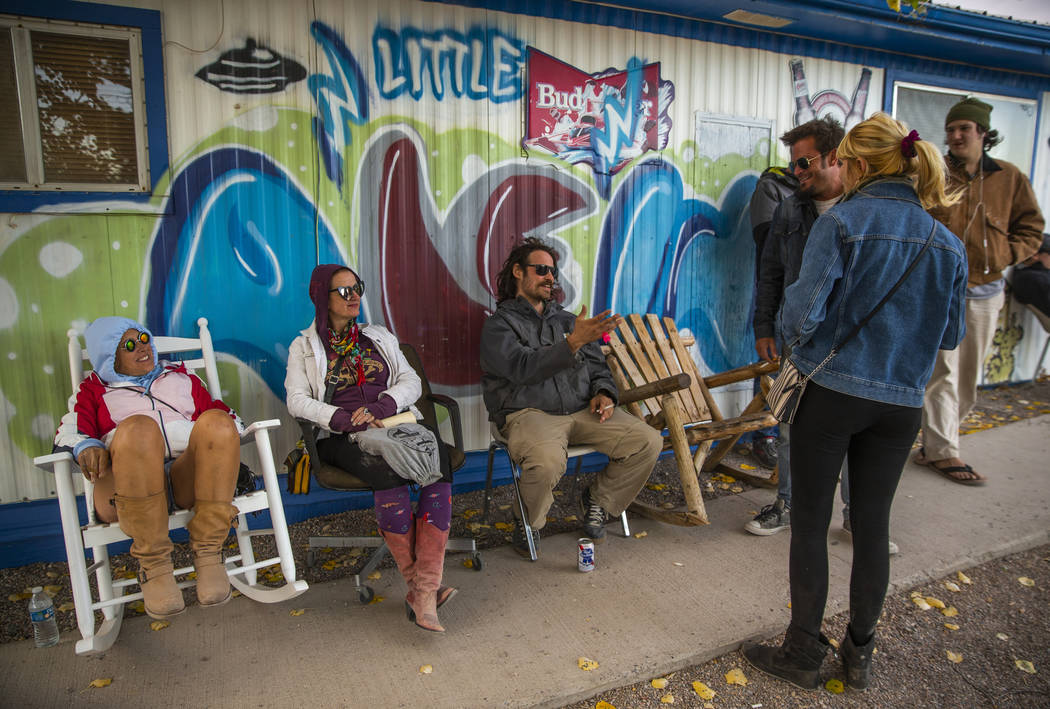 Festivalgoers get some break from the high winds by hanging out in front of the Little'A'Le'Inn ...
