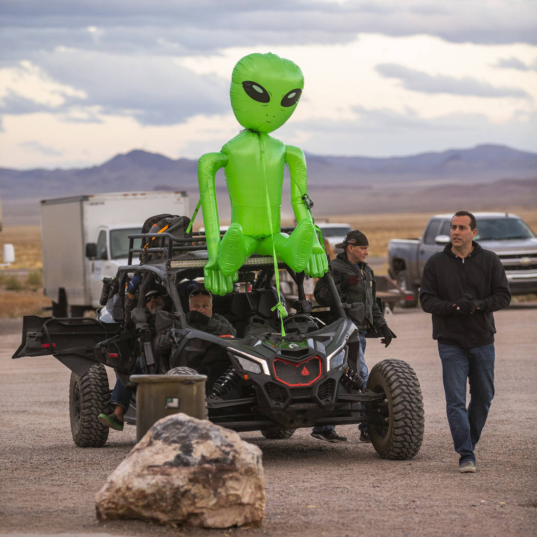 Festivalgoers arrive by all-terrain vehicle with an alien strapped to the top in front of the L ...