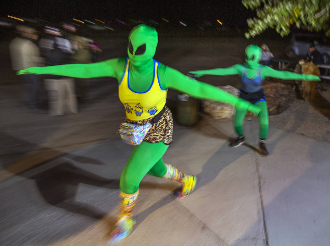 A pair of aliens move about festivalgoers at the Little A'Le'Inn late on the first night of Ali ...