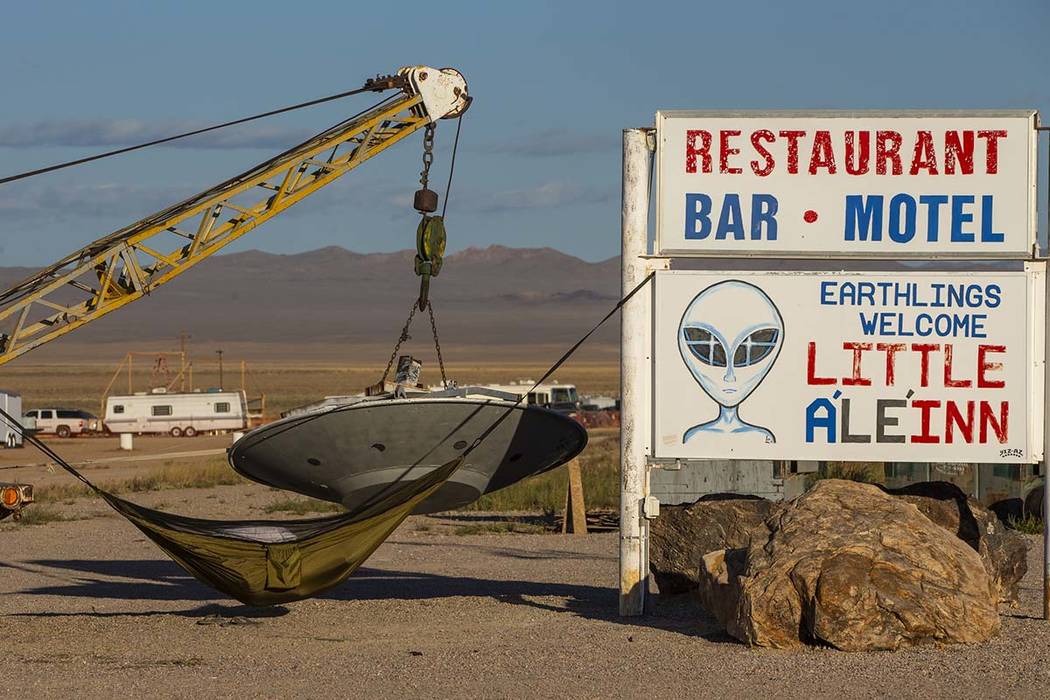 A camper sleeps in a hammock on the sign outside the Little A'Le'Inn which will serve coffee an ...