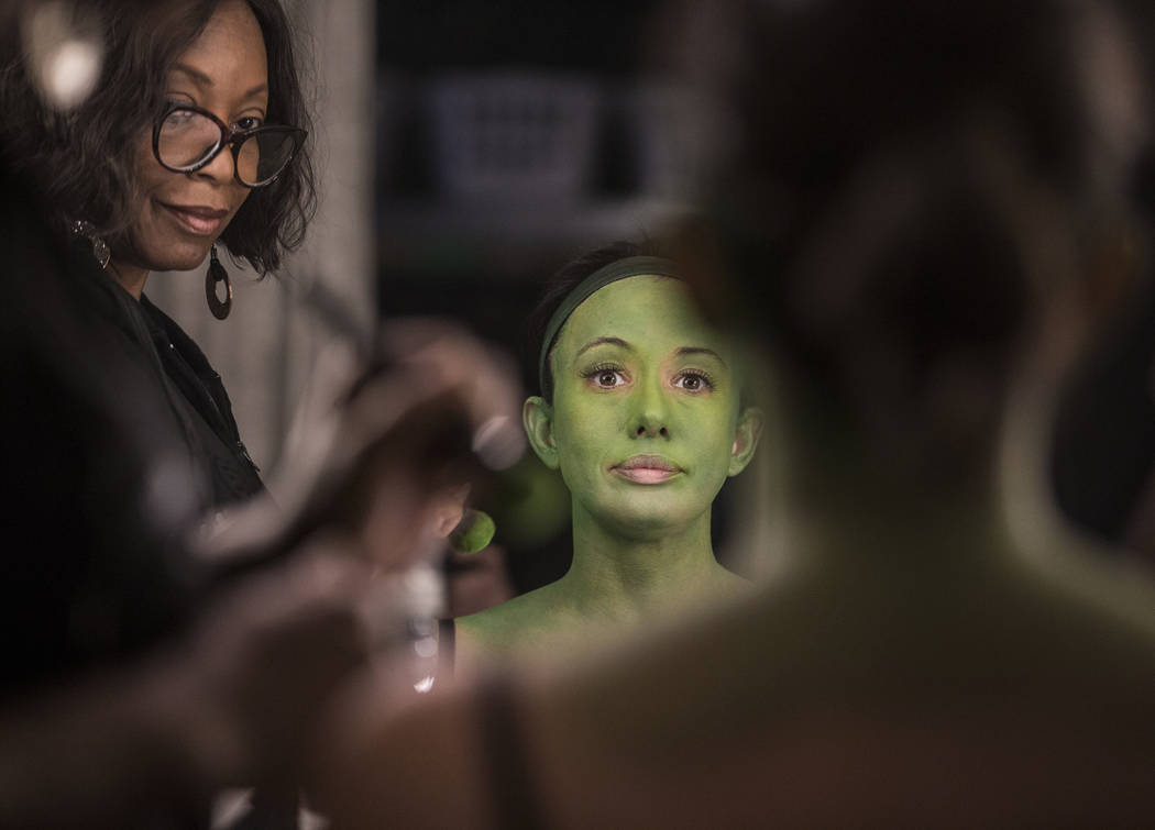 Mariand Torres, right, who plays Elphaba in "Wicked," gets her makeup done by makeup supervisor ...